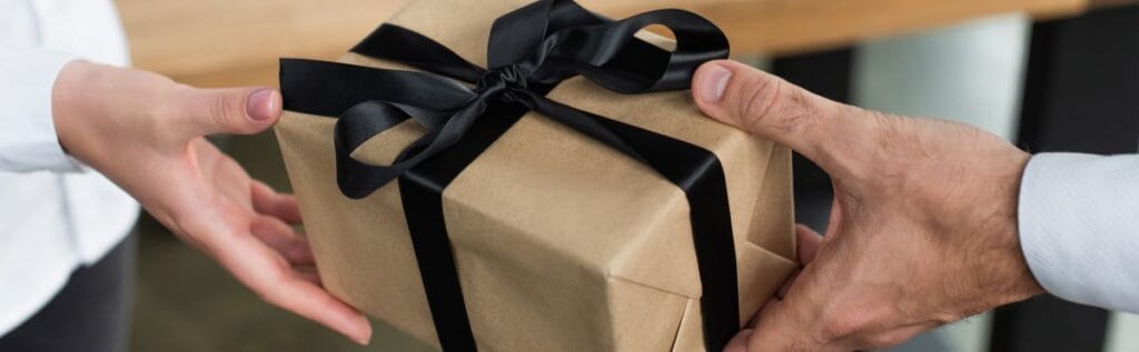 Woman giving employee a company gift at the office