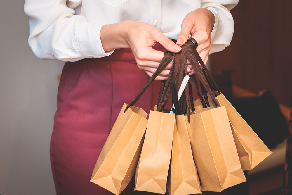 owner celebrating small business anniversary by giving customers customized gifts as part of marketing program